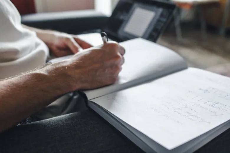 homem escrevendo no caderno, representando a importância da gestão de tempo e o estado de flow